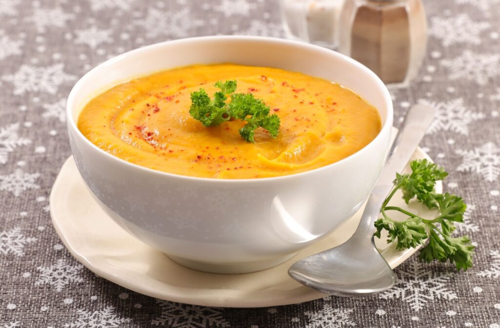 A bowl of yellow soup that is an example of what to eat after getting a root canal